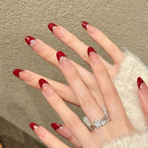 Handmade red French press-on nails with silver glitter and delicate bow accents