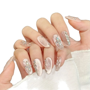 Luxurious nude pink gradient press-on nails with sparkling rhinestones and cat-eye finish