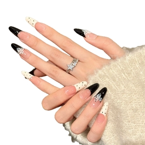 French tip press-on nails with black polka dots and white floral 3D details