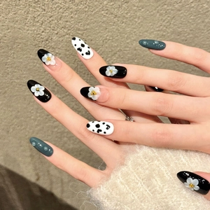 Long oval press-on nails with black floral and heart patterns featuring 3D water drop details
