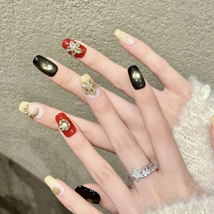 Handmade press-on nails in red, black, and gold with 3D floral accents and cat-eye finish