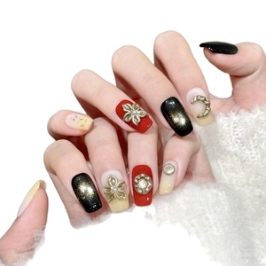 Handmade press-on nails in red, black, and cream with gold 3D floral accents and pearls