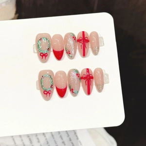 Faux ongles amande de Noël avec nœuds rouges et paillettes vertes sur fond neutre