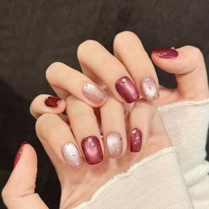 Faux ongles carrés courts avec effet œil de chat bordeaux et strass rose champagne