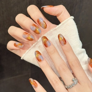 Handcrafted amber and gray marble press-on nails with gold glitter in long oval shape