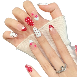 Red and white polka dot almond press-on nails with star patterns and French tip designs