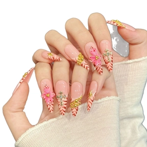 Pink gradient stiletto press-on nails with 3D floral accents and gold cross charms