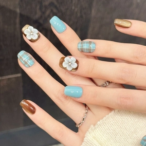 Blue and brown plaid press-on nails with 3D white floral accents and cat-eye finish