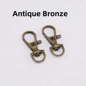 Macro detail of two antique bronze swivel lobster clasps for DIY keychains and bags