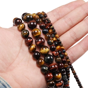 Macro detail of natural multi-color tiger eye beads in various sizes from 4mm to 12mm