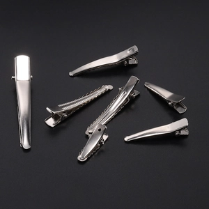 Silver metal duckbill hair clips in various sizes on a black background for DIY styling