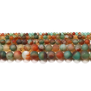 Detailed view of matte natural stone loose beads with forest green and ochre hues