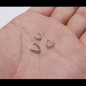 Three silver stainless steel pinch bails for pendant DIY jewelry making held in hand