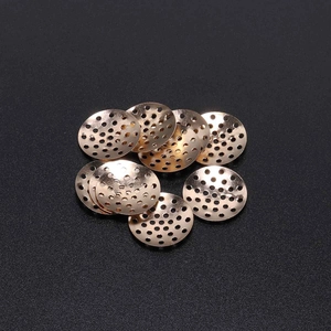 Macro detail of rose gold round perforated metal floral plates for DIY jewelry making