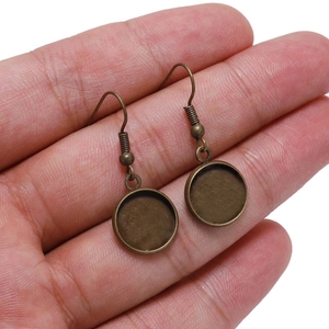 Close-up of bronze DIY earring hooks with round bezel trays for jewelry making