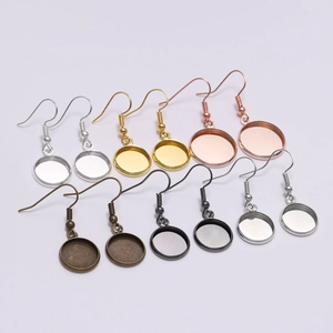 Close-up of assorted metal round bezel earring hooks in gold, silver, and bronze finishes