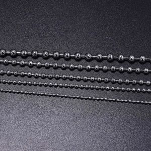Five assorted sizes of polished stainless steel ball chains on a black textured background