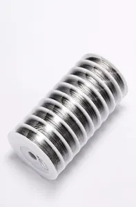 Vista macro de 10 rollos de alambre de acero dorado de 0,38 mm en bobinas blancas para joyas