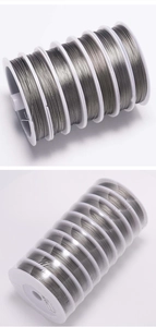 Dettaglio del filo d'acciaio dorato da 0,38 mm su rocchetto per creazione gioielli DIY