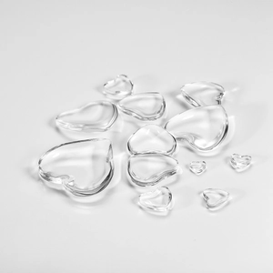 Vista macro di cabochon in vetro trasparente a forma di cuore per creazione gioielli DIY