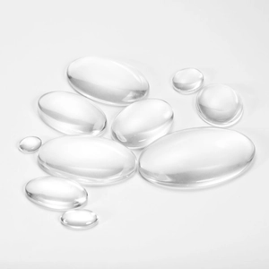 Multiple sizes of clear oval glass cabochons for DIY jewelry making on white background