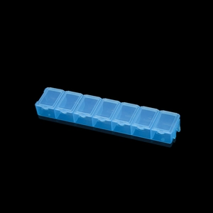 Detailansicht eines blauen 7-Fach Tablettendosierers mit Deckeln auf Spiegeloberfläche