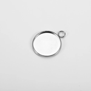 Close-up of a bright silver stainless steel round pendant tray with jump ring for DIY jewelry
