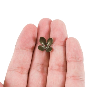 Copriperle a forma di petalo di bronzo tenute in mano per accessori gioielli fai da te