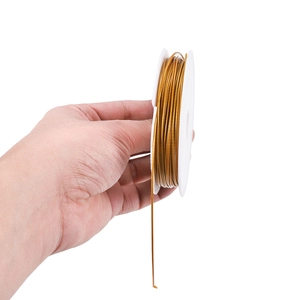 Goldener Edelstahldraht auf weißer Spule für DIY-Schmuck und Perlenarbeiten