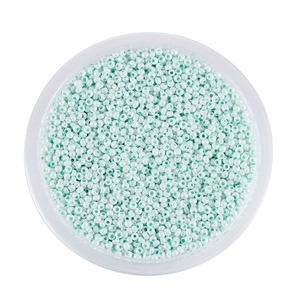 Vista dall'alto di perline di vetro verde menta 2mm in un contenitore rotondo trasparente
