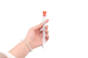 Macro detail of big eye beading needles neatly stored in a clear tube with a red cap