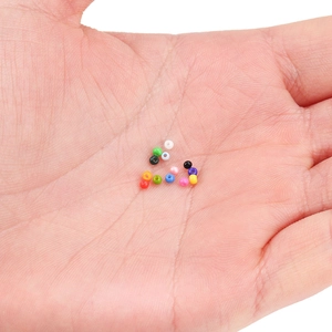 Perline di vetro colorate da 2mm per gioielli fai-da-te mostrate nel palmo della mano
