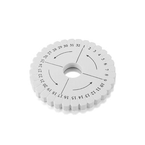 Détail macro du disque de tressage blanc avec fentes numérotées pour la création de bijoux