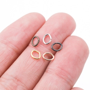 Oval jump rings in five metallic colors held on fingers for DIY jewelry making