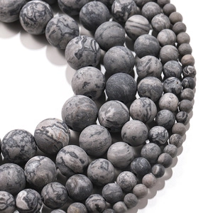 Macro view of matte green line agate beads with natural marble texture and ink patterns