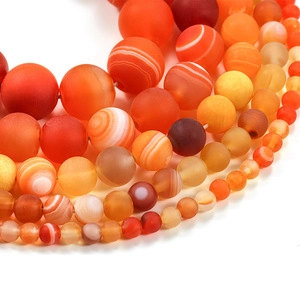Macro detail of matte natural carnelian beads in gradient orange and red tones