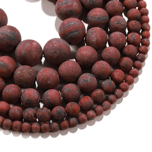 Macro detail of natural agate beads showing red-brown textures and varied sizes