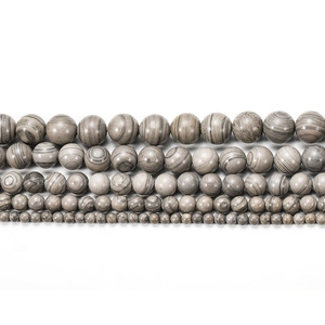 Macro detail of various sizes of matte green line agate beads for jewelry making