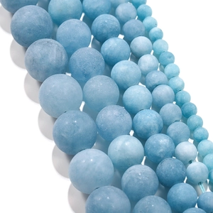 Macro detail of matte aquamarine loose beads in various sizes from 4mm to 12mm