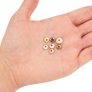 Flat round metal spacer beads in multiple plating colors held on a palm for DIY jewelry