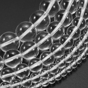 Transparent round quartz beads in various sizes for DIY jewelry making on black background