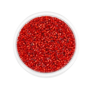Macro shot of 2mm red glass seed beads in a transparent round box for jewelry making