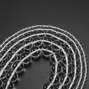 Macro view of transparent quartz beads in various sizes on a dark textured surface