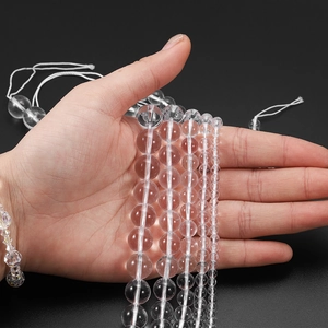 Macro view of clear quartz beads in four different sizes for DIY jewelry making