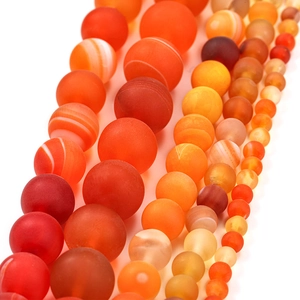 Detail of matte and polished orange banded agate loose beads in varied sizes for DIY jewelry