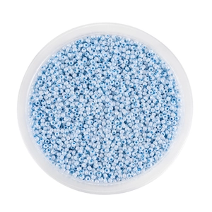 Macro-opname van hemelblauwe 2mm glazen kralen in een witte kom voor DIY-sieraden