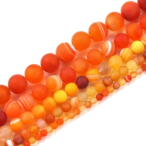 Macro detail of matte orange banded agate loose beads in various sizes for DIY jewelry making