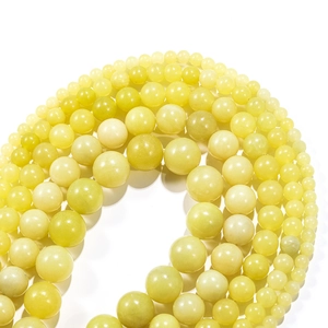 Macro detail of various sizes of polished natural lemon jade round beads for DIY jewelry making