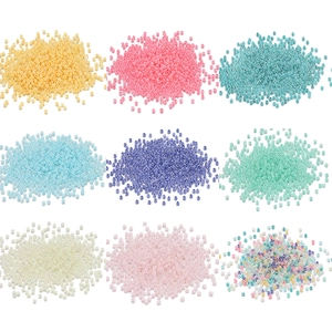 Neun bunte Glasperlen-Sets für DIY-Schmuckherstellung auf weißem Hintergrund