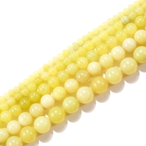 Detailed view of light yellow lemon jade smooth loose beads in various sizes from 4mm to 14mm
